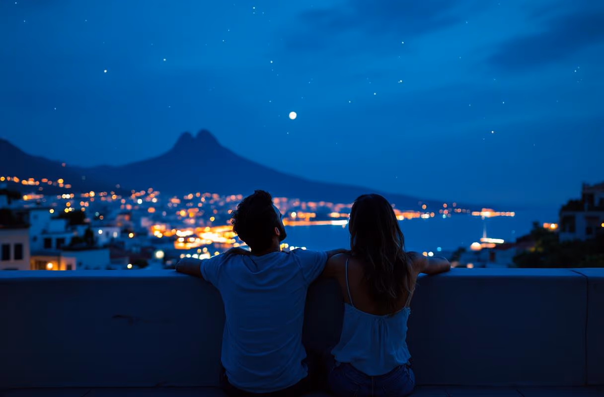 A couple on a Vomero rooftop at blue hour with the Bay of Naples and Vesuvius silhouette behind