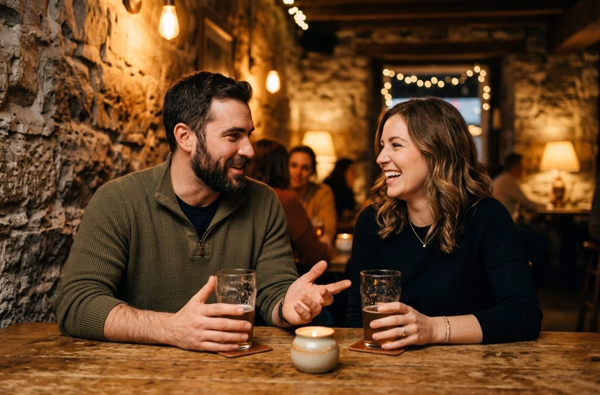 A couple talking over drinks at a warm pub table in Ottawa's ByWard Market in the evening