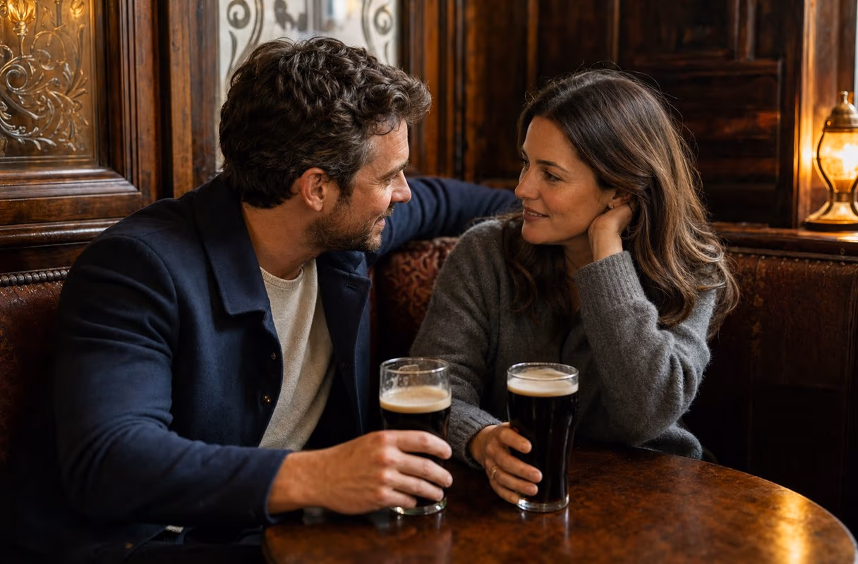El snug del pub — el rincón privado original de Irlanda para conversaciones honestas Una pareja conversando en voz baja en el snug de madera de un pub tradicional de Dublín